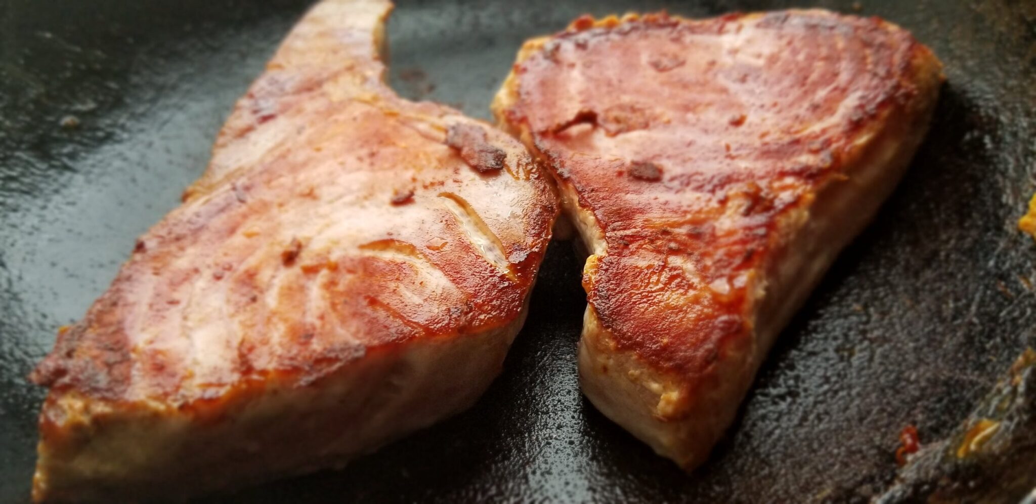 Salmon cooking in cast iron pan